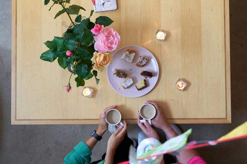 A birds eye view of a table with people drinking tea around it